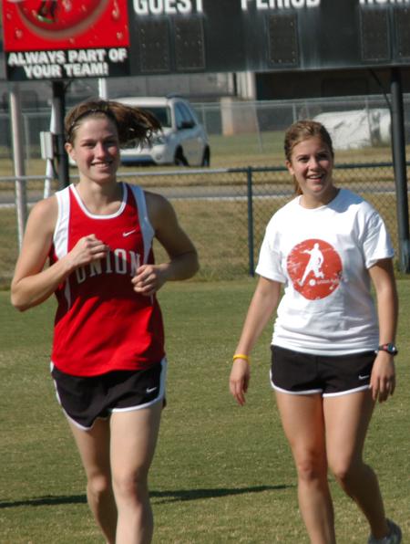 Hannah Staggs (left) and Danielle Partain enjoy their team victory in the Union University Cross Country Invitational. - Photo by Steven Aldridge