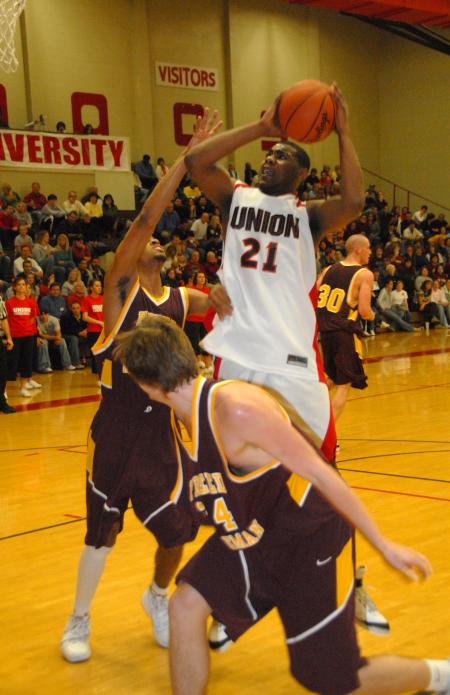 Brian Lake, junior, takes shot over two Freed-Hardeman (Tenn.) University opponents. - Photo by Morris Abernathy