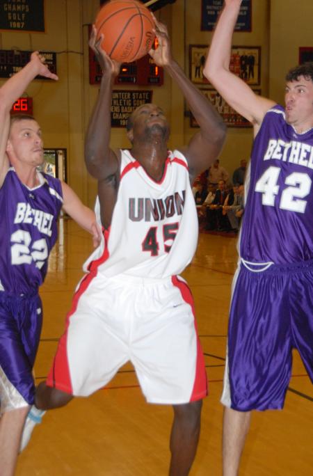Roland Banhoro (45), freshman center, prepares to a take a shot between two Bethel (Tenn.) College defenders. - Photo by Morris Abernathy