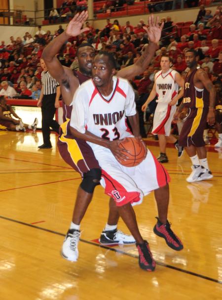 Junior guard/forward Greg Truvillion drives around a Robert Morris (Ill.) College defender to score in Union's Homecoming victory. - Photo by Morris Abernathy