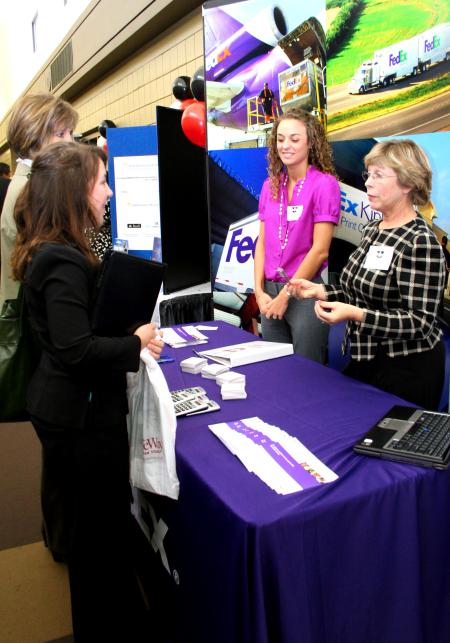 Mallory Dunseath and Amy Armstrong, representatives from FedEx, speak with Libby Ford, senior accounting major, and Karen Miller, accounting professor, about opportunities at FedEx during the CareerU fair.  - Photo by Kristi McMurry Woody