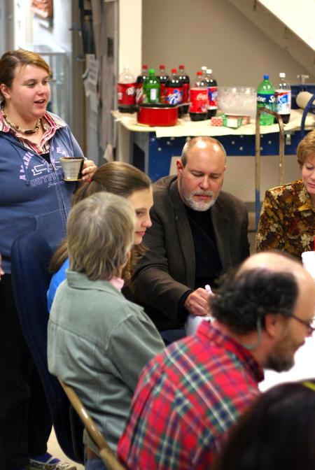 Megan March, senior art major, chats with the families of art faculty members Chris Nadaskay and Lee Benson at the annual art department Thanksgiving dinner. - Photo by Kristi McMurry Woody