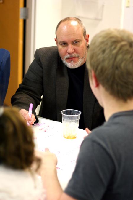 Art Professor Chris Nadaskay chats with Ben Watson, junior art major, at the annual art department Thanksgiving dinner. - Photo by Kristi McMurry Woody