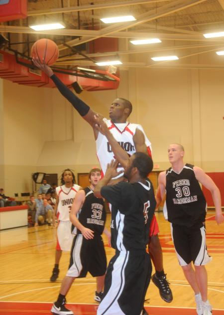 Sophomore forward Antoine Joseph lays the ball in the basket over defenders. - Photo by Morris Abernathy