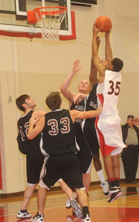 Junior guard Keith Tolliver (35) makes a basket over Freed-Hardeman (Tenn.) defenders. - Photo by Morris Abernathy