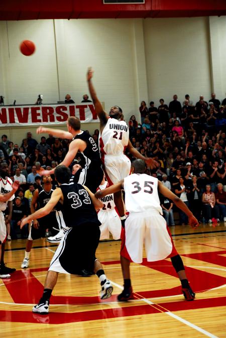 Brian Lake (21) jumps for the ball at tip off in Union's 105-78 win over Freed-Hardeman (Tenn.) University in the TranSouth Conference Tournament Championship game. - Photo by Kristi McMurry Woody