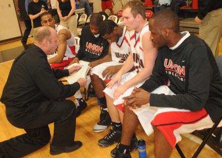 The Bulldogs review the gameplan with Head Coach Ralph Turner prior to tip off. - Photo by Morris Abernathy