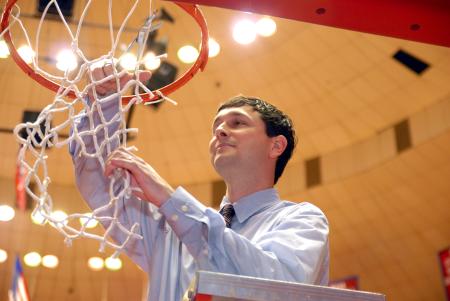 Coach Mark Campbell cuts down a piece of the net at Oman Arena after winning the 2009 NAIA championship. - Photo by Kristi McMurry Woody