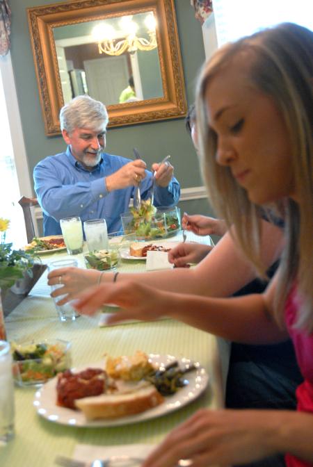 Be Our Guest host, Dr. Bill Nettles, makes his salad as Emily Chambers, freshman youth ministry major, prepares to partake of the delicious meal. - Photo by Kristi McMurry Woody