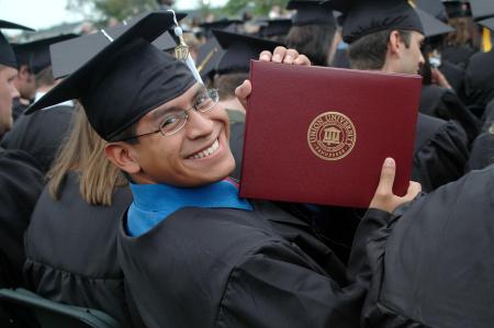 Austin McClain shows off his diploma after walking the stage during the spring graduation ceremony on Saturday, May 23, 2009. - Photo by Beth Spain