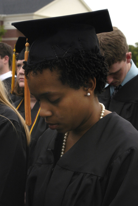 Amber-Rose Hawkins prays with President Dockery and the rest of the graduates during spring graduation. - Photo by Sarah Palmer Goff