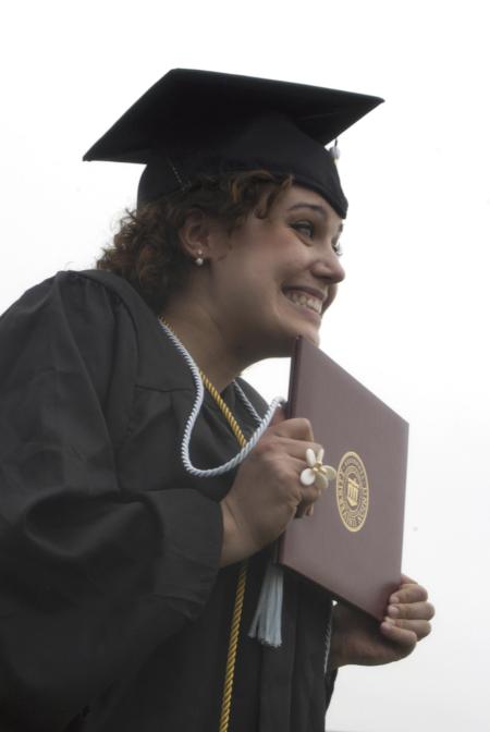 Theatre graduate Natalie Newberry celebrates as she receives her diploma during spring graduation. - Photo by Sarah Palmer Goff