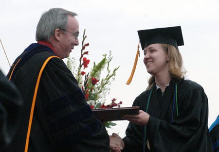 President David S. Dockery presents Social Work major Emily Price with her diploma at Spring Graduation 2003. - Photo by Jim Veneman