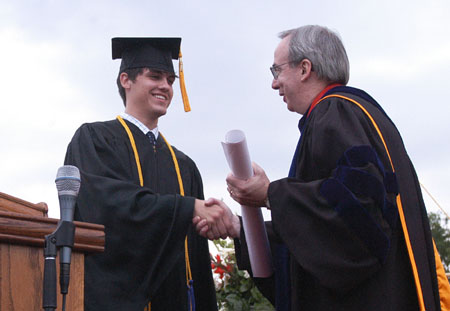 Class of 2003 President Casey Stafford presents President Dockery with the plans for an amphitheater as the senior gift at Spring Graduation 2003. - Photo by Jim Veneman