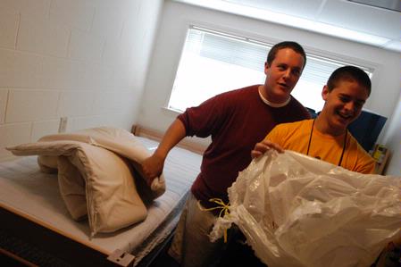 Jeremy Isbell, freshman music major from Jackson, Tenn., and his brother, Kevin, an Union alum, joke while putting a mattress pad onto his new bed. - Photo by Sarah Palmer Goff
