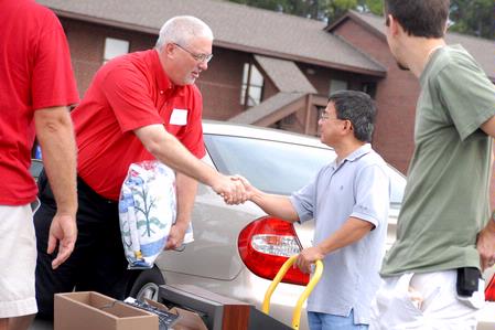 Don Van, professor of engineering, shakes hands with Union parent, David Adkins, while helping students move-in on freshman move-in day. - Photo by Kristi McMurry Woody