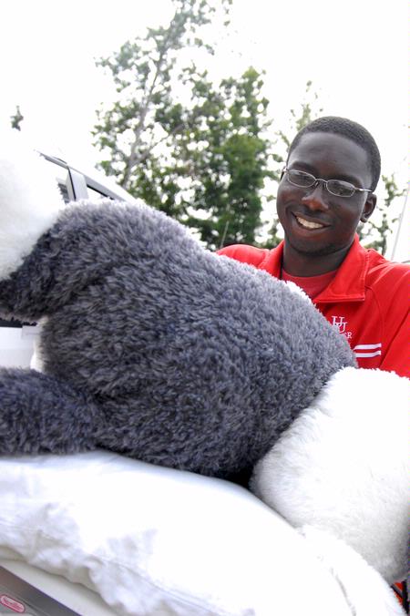 Hani Nyabam, senior computer science major, helps an incoming freshman move things into the dorms on freshman move-in day.
 - Photo by Kristi McMurry Woody