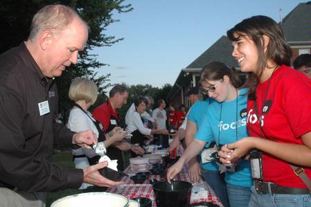 Mark Kahler, assistant vice president for university communications, serves ice cream to junior Haley Gallagher during an ice cream social at President Dockery's house during new student orientation. - Photo by Beth Spain