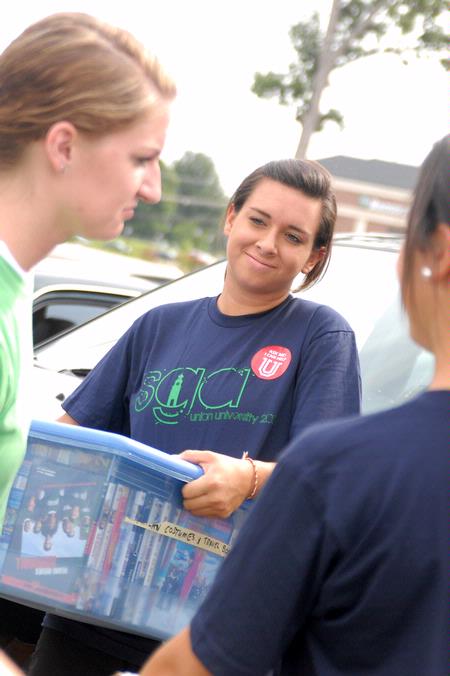 Meredith Gunn, sophomore nursing major, helps move an incoming freshman move into the dorms on freshman move-in day. - Photo by Kristi McMurry Woody