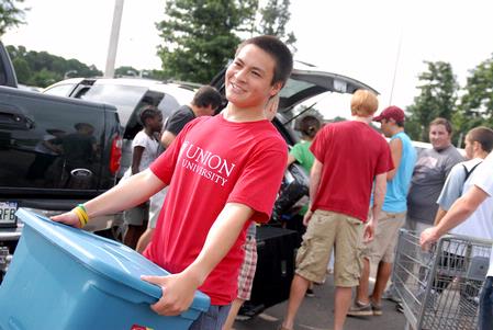 Peter Yu, sophomore, helps move an incoming freshman into their room on freshman move-in day. - Photo by Kristi McMurry Woody