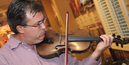 Gavin Richardson, associate professor of English, plays the violin along with a faculty band before the Faculty/Staff Dinner. - Photo by Morris Abernathy