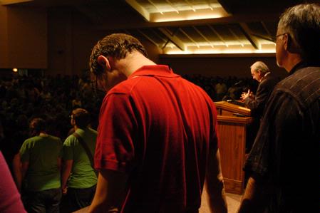 Greg Thornbury joins hands with Rich Grimm and other professors, parents, and upperclassmen as President Dockery prays for students at the close of the new student worship service during orientation. - Photo by Sarah Palmer Goff