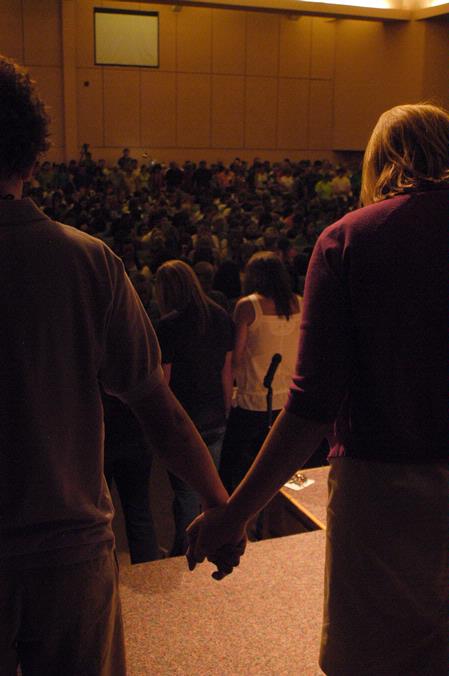 Dean of Students Kimberly Thornbury (right) joins hands with Josh Allen, senior Christian studies major, and other professors, parents, and upperclassmen as President Dockery prays for the new students at the close of the new student worship service during orientation. - Photo by Sarah Palmer Goff