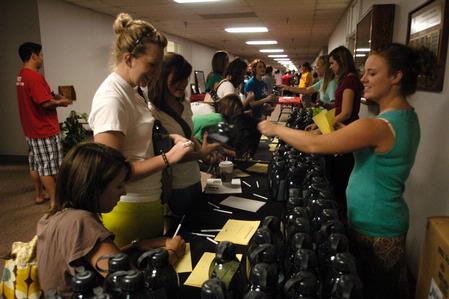 Danielle Blackstone, senior biology major, hands out water bottles to freshmen Sara Tate and Megan Pace at the organization fair.           - Photo by Sarah Palmer Goff