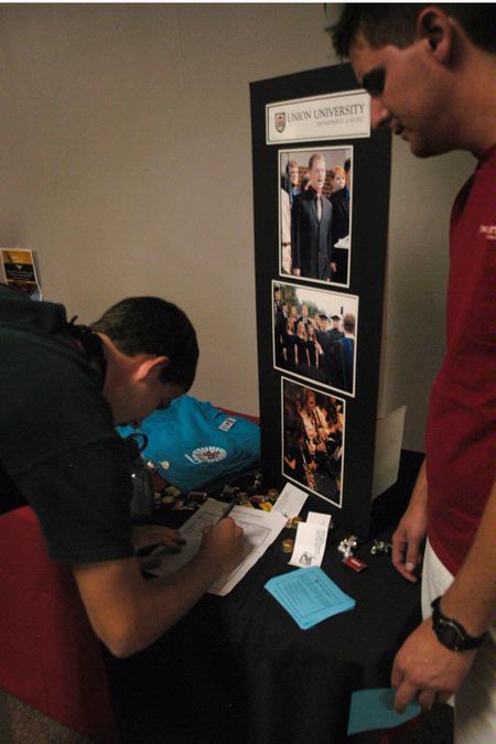 Freshman Matthew Cox signs up on the Department of Music interest list after talking with Jamie Evans, senior music education major, at the organization fair.      - Photo by Sarah Palmer Goff