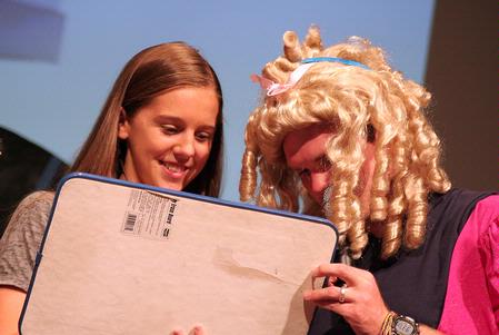 One of the hosts of the SAC game show helps Freshman Paige Parker draw a picture on her price board. This annual game show is a way for freshmen to win prizes and have fun. - Photo by Kristi McMurry Woody