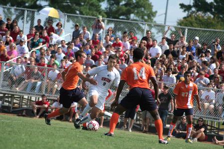 Guilherme Reis, freshman, dribbles the ball away from his Brewton Parker opponents. Watching him is a full crowd of fans enjoying Union's new soccer field stands. - Photo by Kristi McMurry Woody