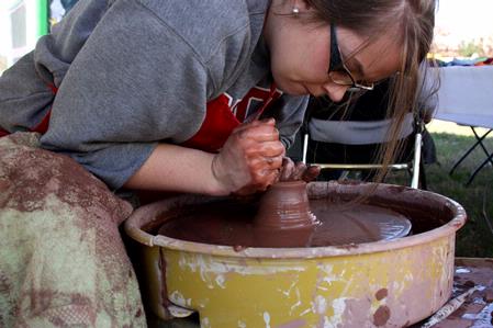 Paige Ward, senior art major, creates pottery during Arts in the Park during Homecoming 2009. - Photo by Megan Bailey