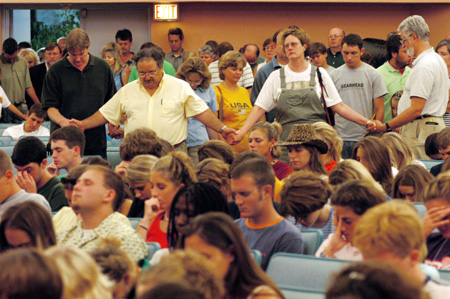 Families encircle their students in prayer during the FOCUS 2003 worship service on Saturday night. - Photo by Justin Veneman