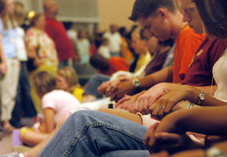 The Freshman class joins hands in prayer during the worship service on Saturday night during FOCUS 2003.  - Photo by Justin Veneman