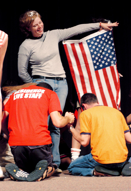 As FOCUS leader Emily Brown imitates a flag pole in the 2003 FOCUS show, other leaders surround her in a <i>See You At The Pole</i> prayer. - Photo by Justin Veneman