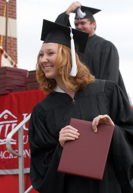 Digital Media Studies major Ginger Rowlett cheeses for the camera shortly after receiving her diploma at Spring Graduation 2003. - Photo by Jim Veneman