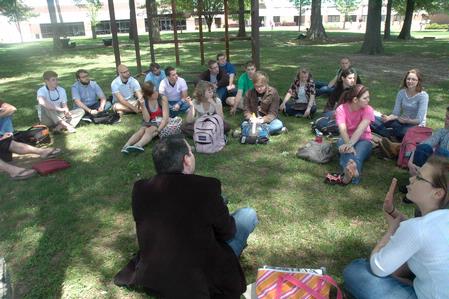 Students engage in discussion under the shade during a History of Christianity and Pop Culture class with Dr. Keith Bates, Assistant Professor of History. - Photo by Beth Spain