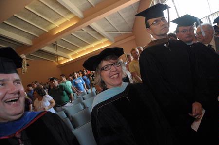 Dottie Myatt, assistant dean for teacher education, laughs with her colleagues as the faculty files into chapel for Awards Day.  - Photo by Morris Abernathy