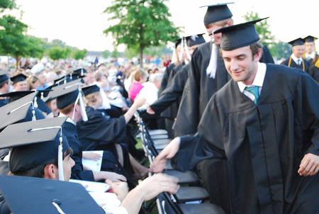 Josh Allen, graduating Christian studies major, high-fives classmates as he waits in the graduation line at the Spring 2010 Graduation Ceremony. - Photo by Abigail Harris