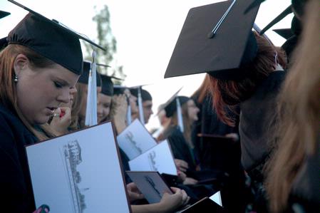 Graduating art major, Katy Pope, reviews her diploma after receiving it during the Spring 2010 graduation ceremony. - Photo by Beth Spain