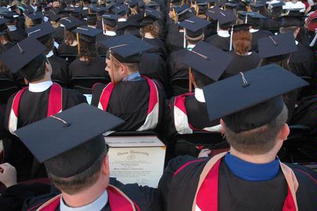 Masters graduates review their diplomas during the Spring 2010 graduation ceremony. - Photo by Beth Spain