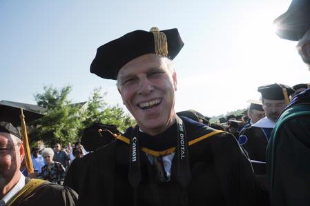 Dr. Steven Carls, University Professor of History and Department Chair, laughs as he stands for the processional at the spring 2010 commencement ceremony.  - Photo by Morris Abernathy