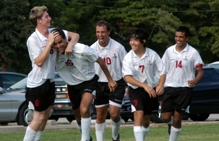 Duncan Nicol (6) and other teammates congratulate Alexandre Pereira (16) after one of his goals. - Photo by Jonathan Blair