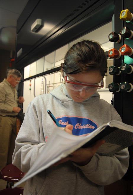 Students take notes in chemistry lab after working on an experiment. - Photo by Morris Abernathy