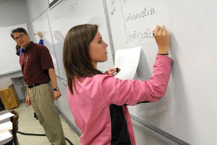 Dr. Troy Riggs, professor of mathematics, watches as his students write their homework problems on the board before class. - Photo by Morris Abernathy