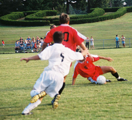 Daniel Lee (5) dives to stop the ball.  Kekec Zivkovic (10) looks on. - Photo by Uncredited