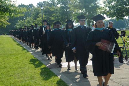 Graduates make their way to their seats for summer graduation on the Great Lawn. - Photo by Morris Abernathy