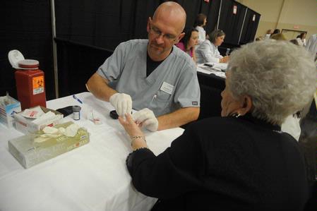 Nurse Paul Mayer, director of health services, student services, works at the health fair as part of the Senior Adult Extravaganza. - Photo by Morris Abernathy