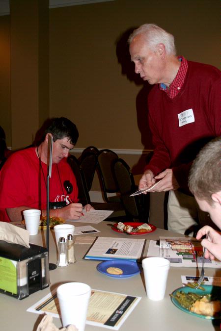 Stephen Carls, university professor of history and department chair, hands out information about the history department to new students during the Dinner with your Department event. - Photo by Deanna Santangelo