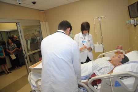 Pharmacy students Frank Ramirez and Kristen Duncan work on a simulation while a tour of Providence Hall is given after the dedication ceremony.  - Photo by Morris Abernathy